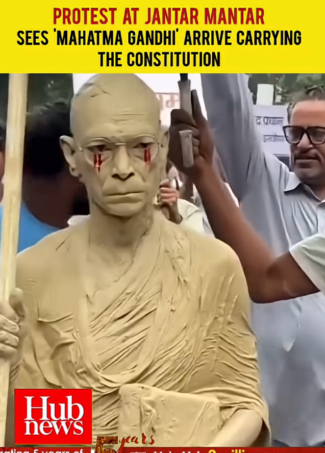 Image of protester dressed as M.K. Gandhi. Screenshotted from Northeast Media Hub video